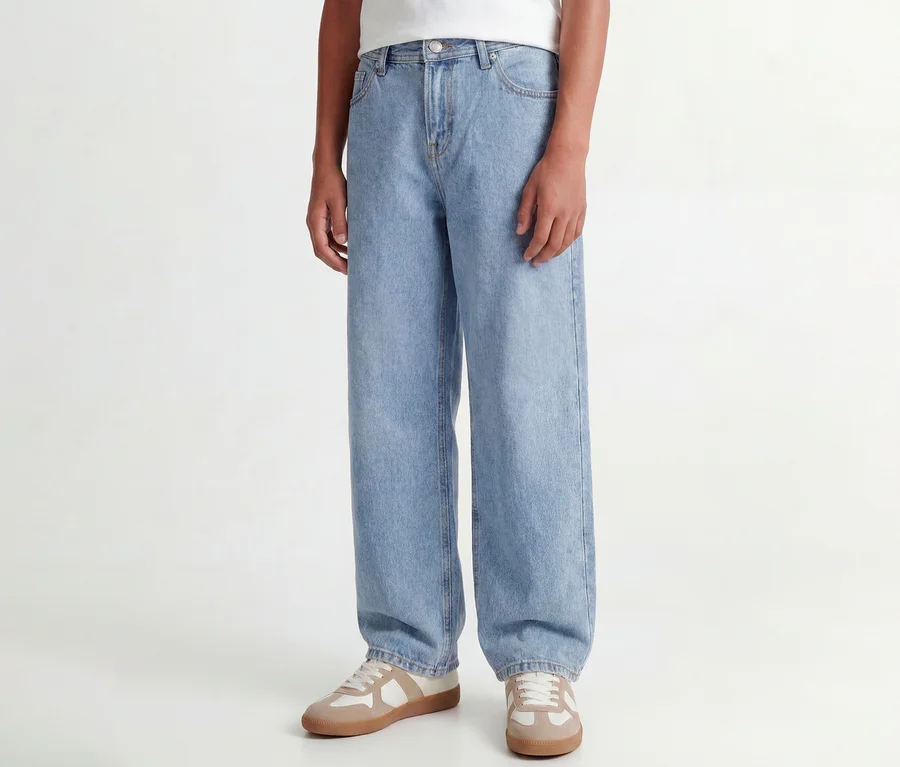 Person trägt hellblaue Jack&Jones JJOrginial Alex Jeans und beige-weiße Sneaker.