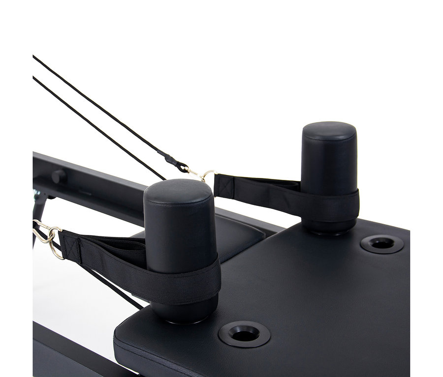 Nahaufnahme eines schwarzen Christopeit Pilates Reformer 2000 mit gepolsterten Stützen und schwarzen Riemen.