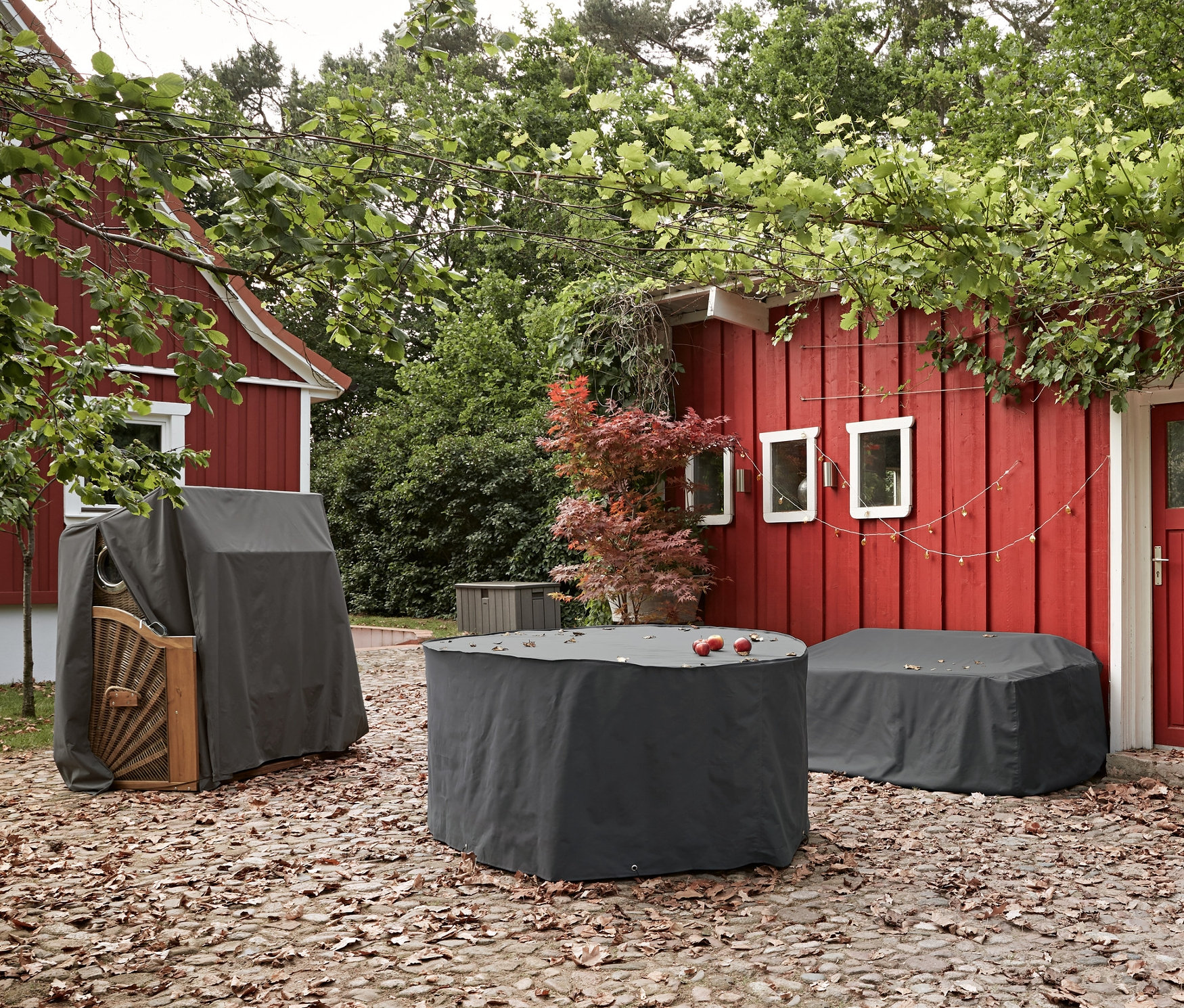 Auf einer gepflasterten Terrasse befinden sich Premium-Esstischset-Schutzhüllen, Premium-Loungemöbel-Schutzhülle »Gartensofa« und Premium-Schutzhülle für Strandkörbe.