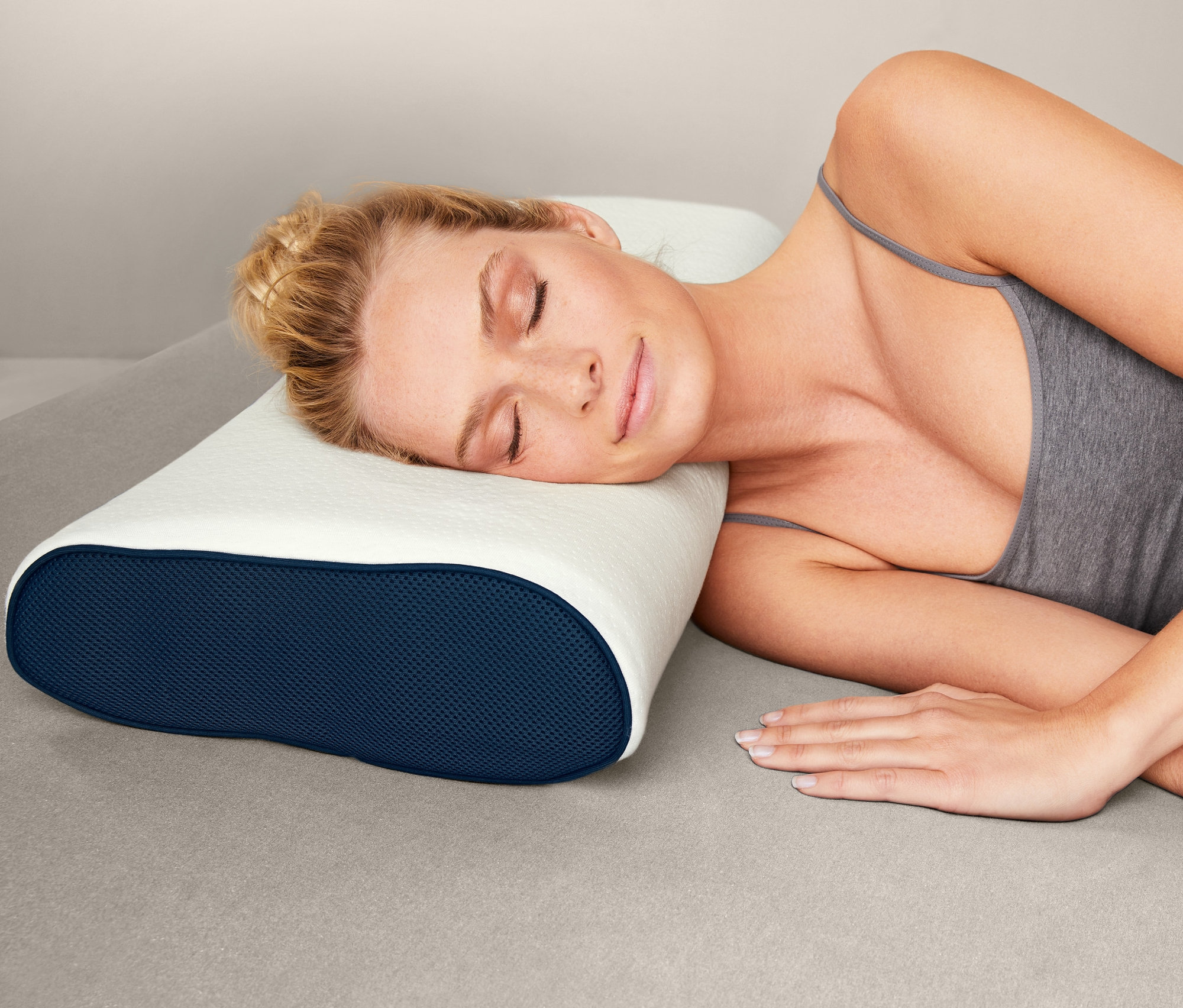 Frau schläft auf der Seite auf einem irisette® Gel-Nackenstützkissen mit blauem Rand.