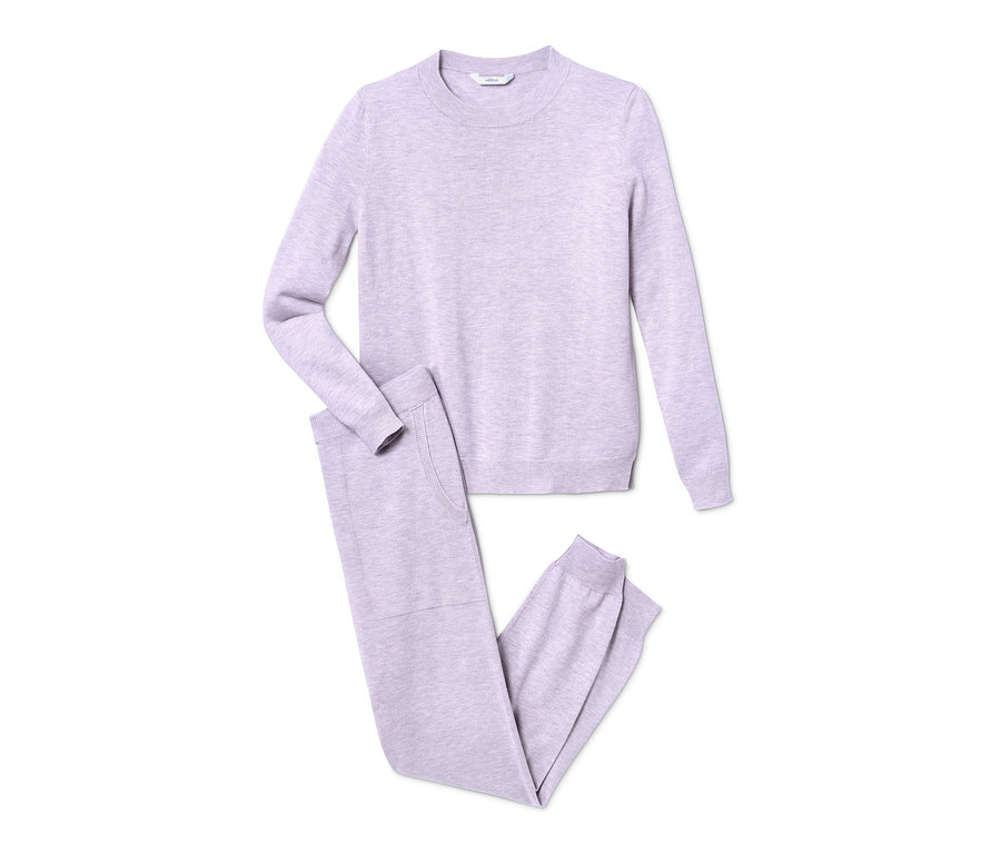 Ein helllila Feinstrick-Hausanzug, Pullover und Hose liegen auf weißem Hintergrund.