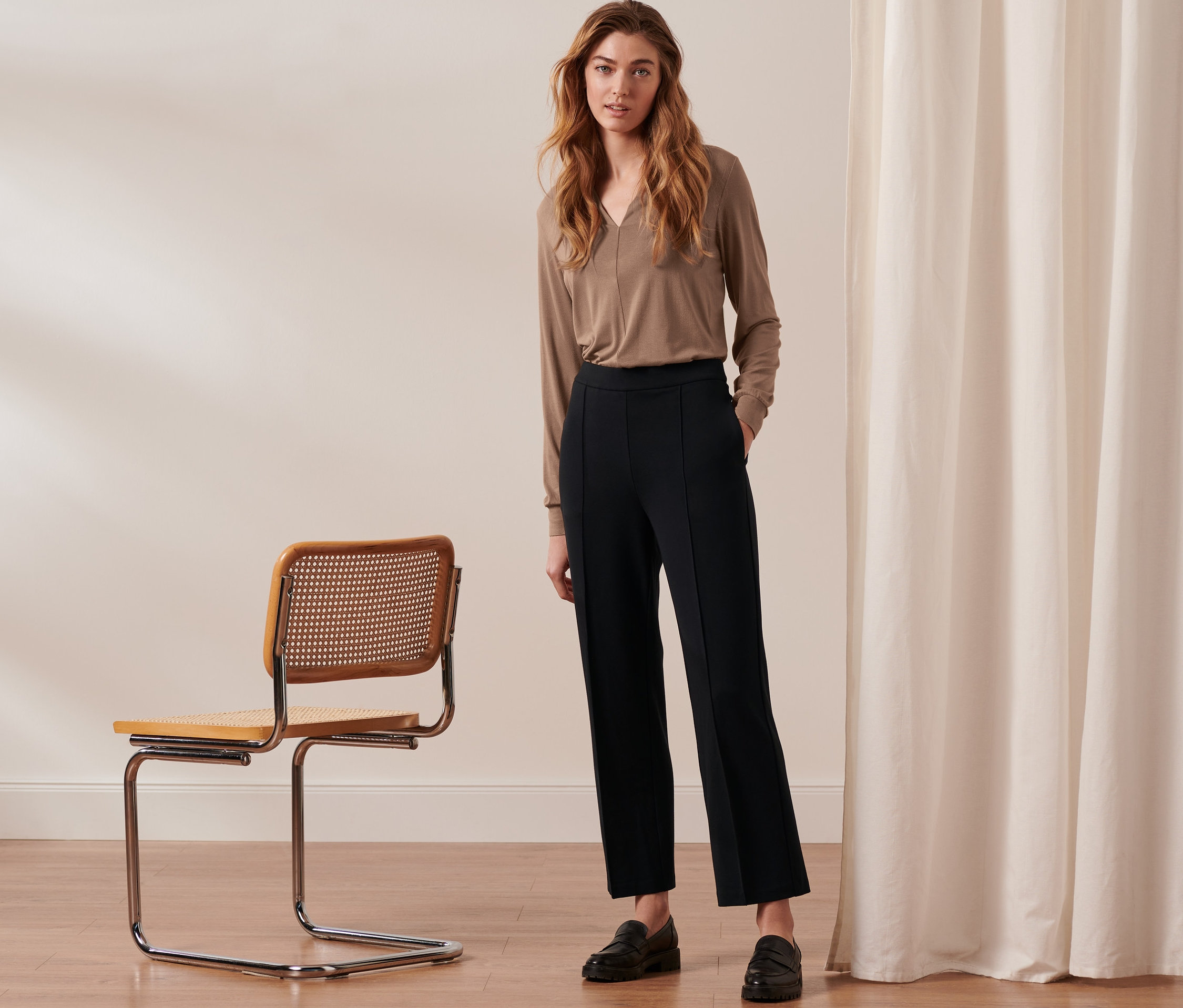 Frau steht und trägt eine schwarze Jerseyhose mit Biese.