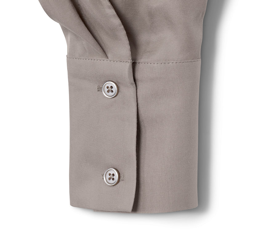 Detail einer Satinbluse mit Knöpfen.