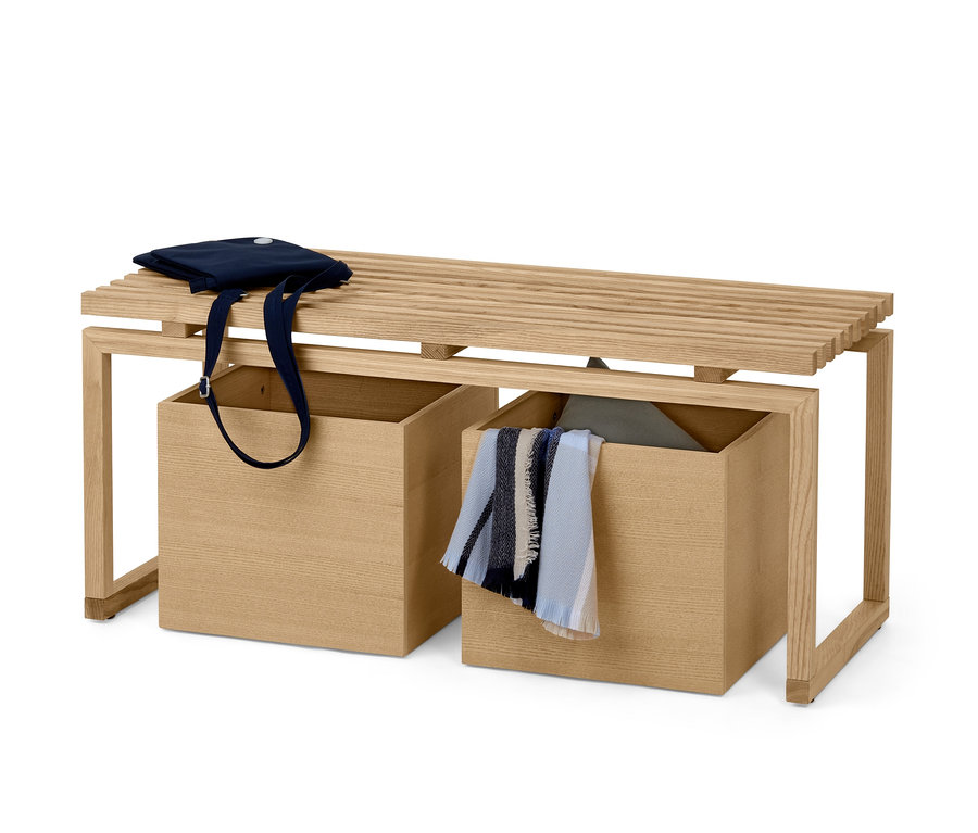 Holzbank mit zwei Aufbewahrungsboxen, auf der Bank liegt eine blaue Tasche.