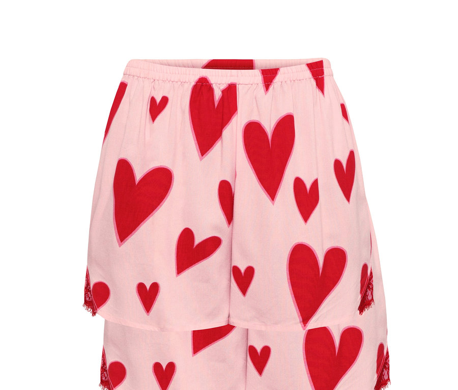 Detailansicht einer rosa Shorty-Pyjama mit rotem Herzmuster.