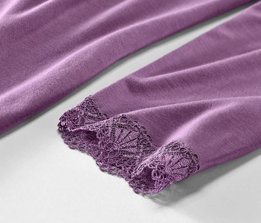 Detailansicht eines violetten Nachthemds mit Spitze am Ärmel.