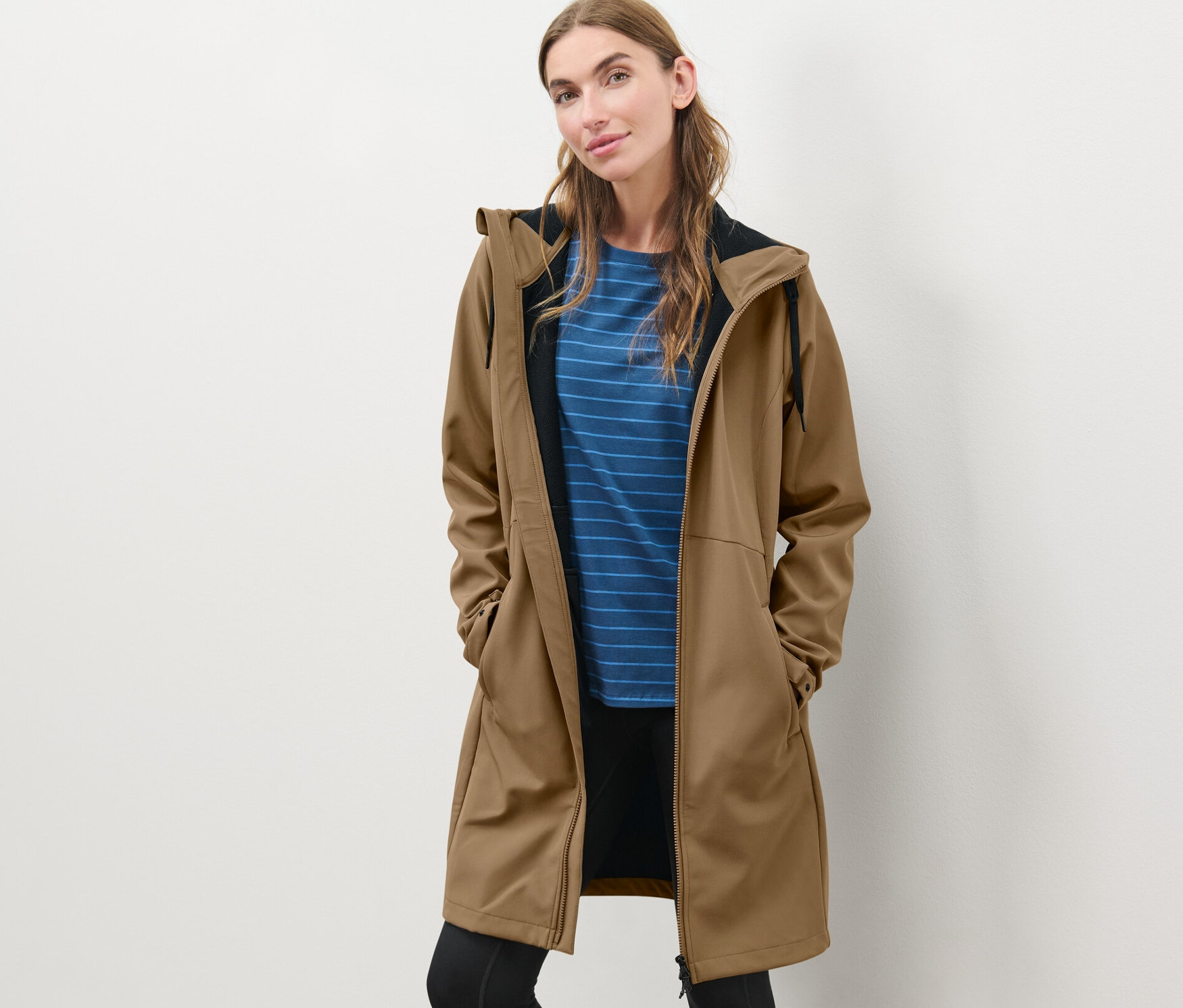 Frau posiert in einem Softshellmantel in Nougat.