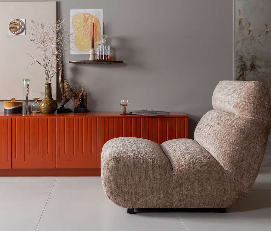 Orangefarbene Kommode mit Dekorationen und beiger BePureHome Sessel »Observe« in einem Wohnzimmer.