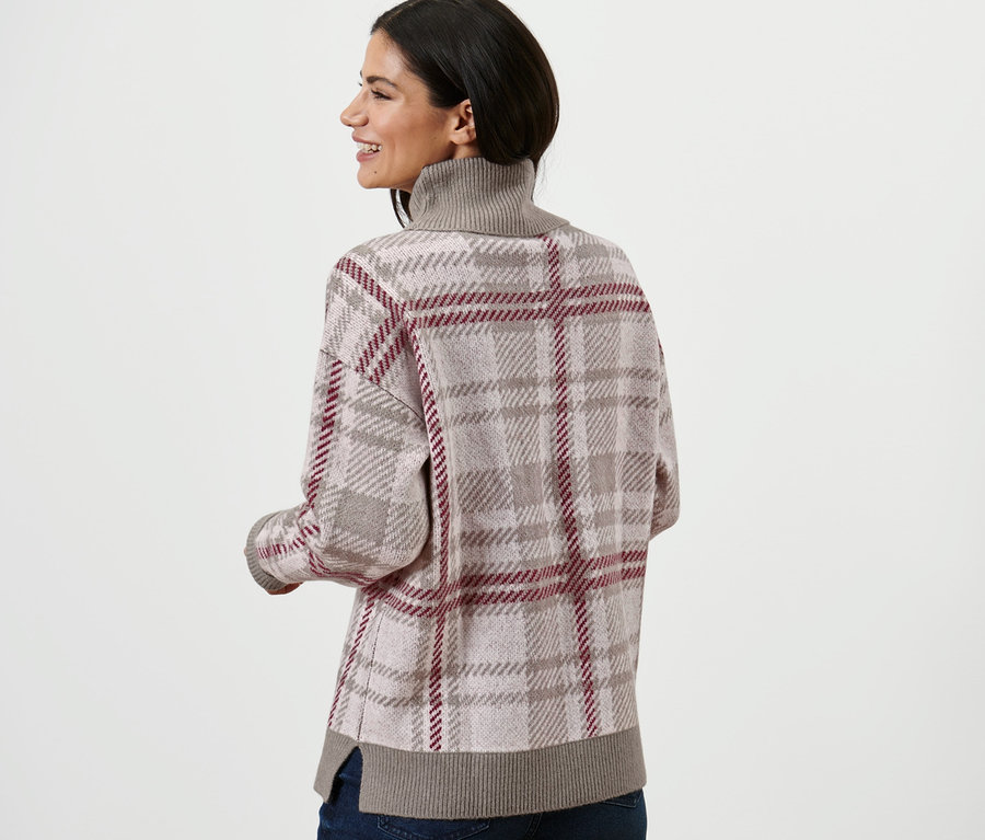 Frau trägt einen Strickpullover mit Rollkragen und Jeans.