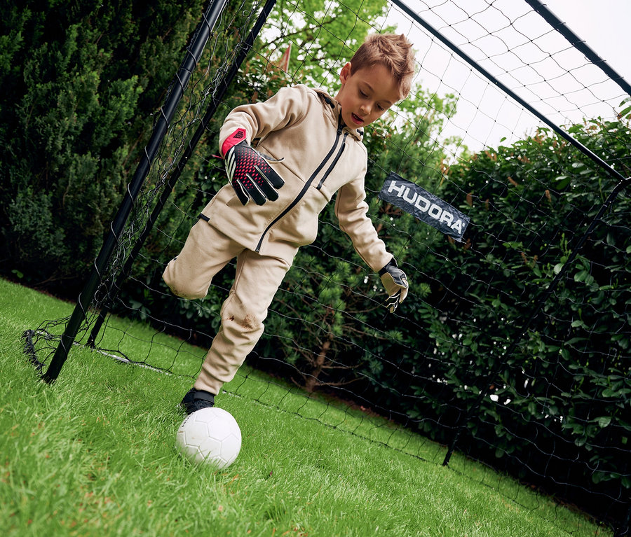 Junge tritt weißen Fußball vor HUDORA Fußballtor »Solid 25«.