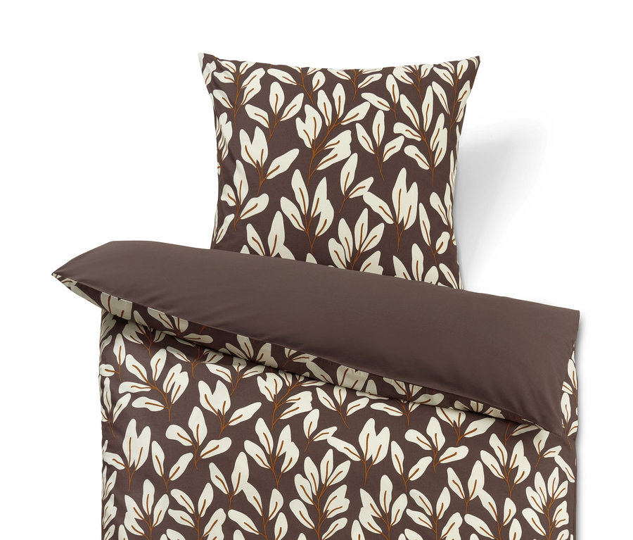 Braune Bettwäsche mit Blättermuster und einem braunen Kissen.