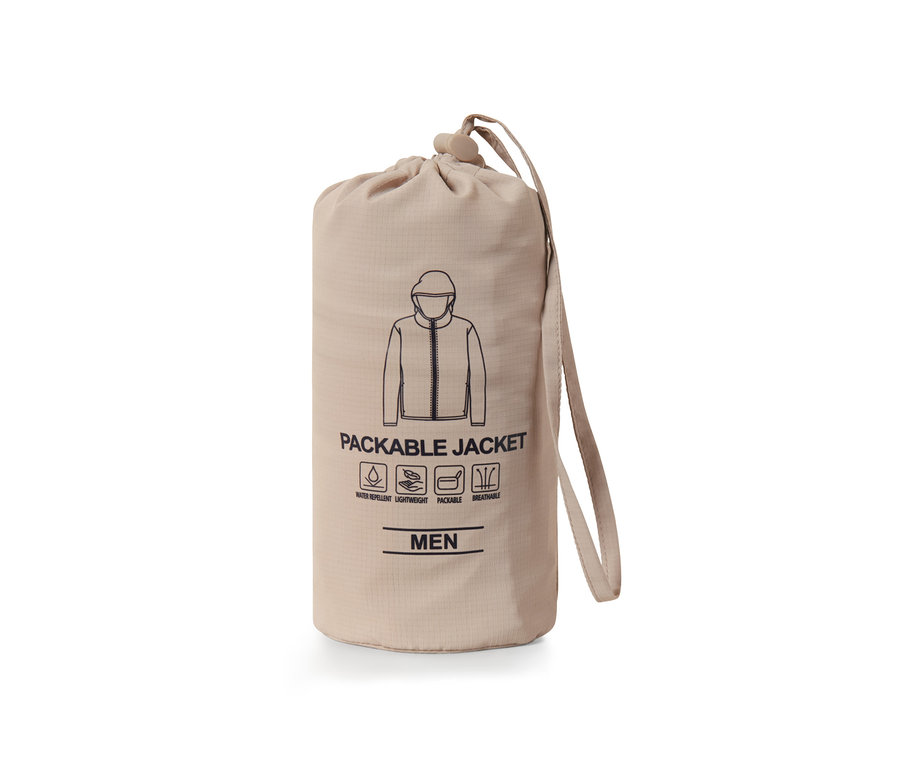 Eine verpackte Funktionsjacke »pack me« in einem beigen Beutel mit Kordelzug.