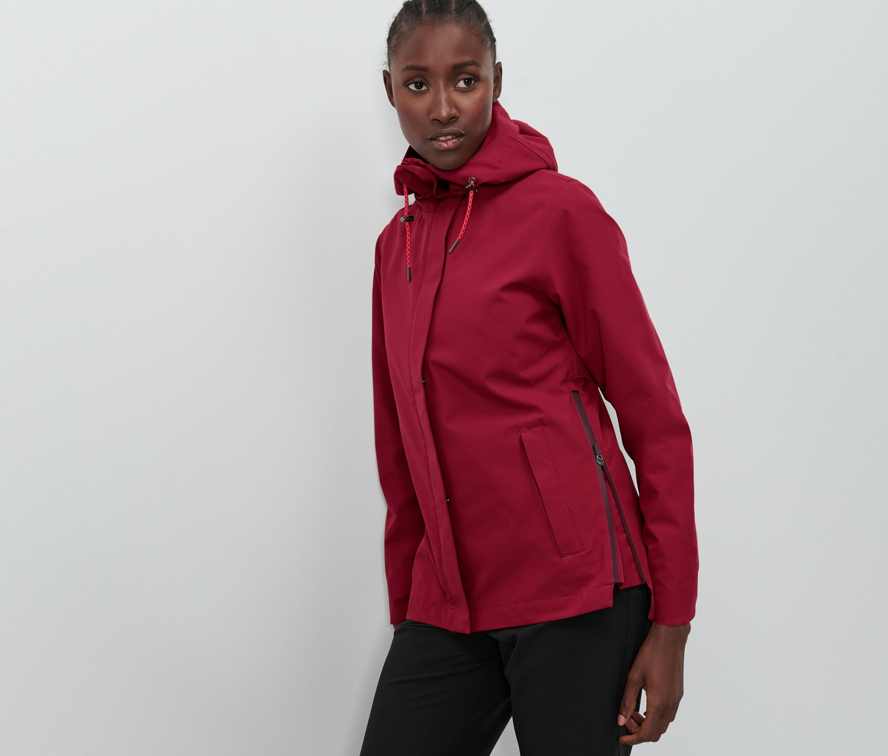 Frau posiert in bordeauxfarbener Funktions-Outdoorjacke.