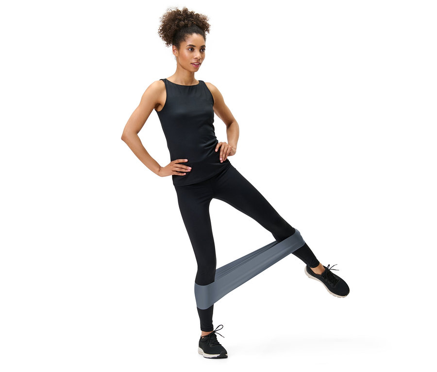 Frau trainiert mit 2 Fitnessbändern an den Beinen.