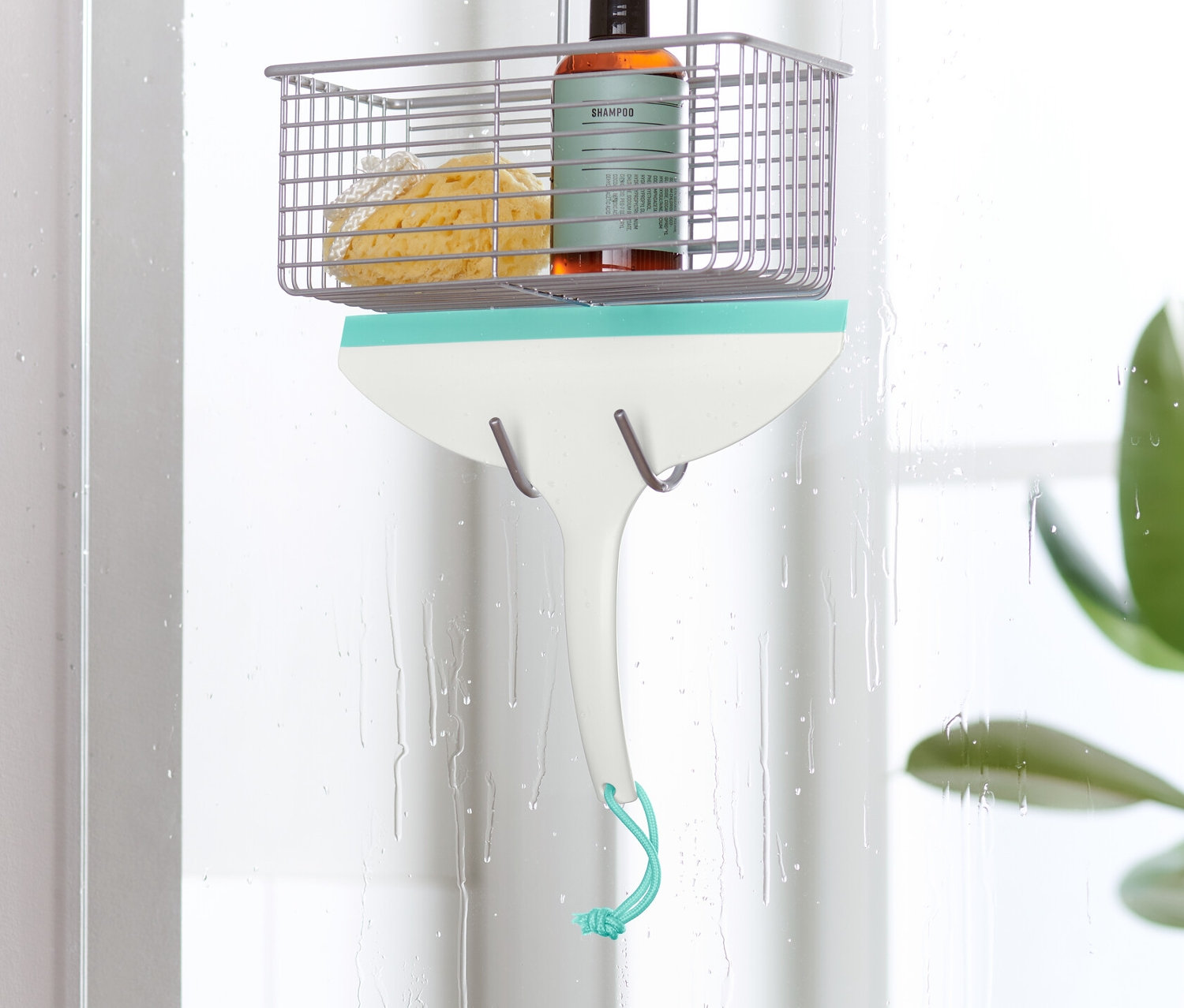 Ein Badwischer hängt an einer Duschwand.