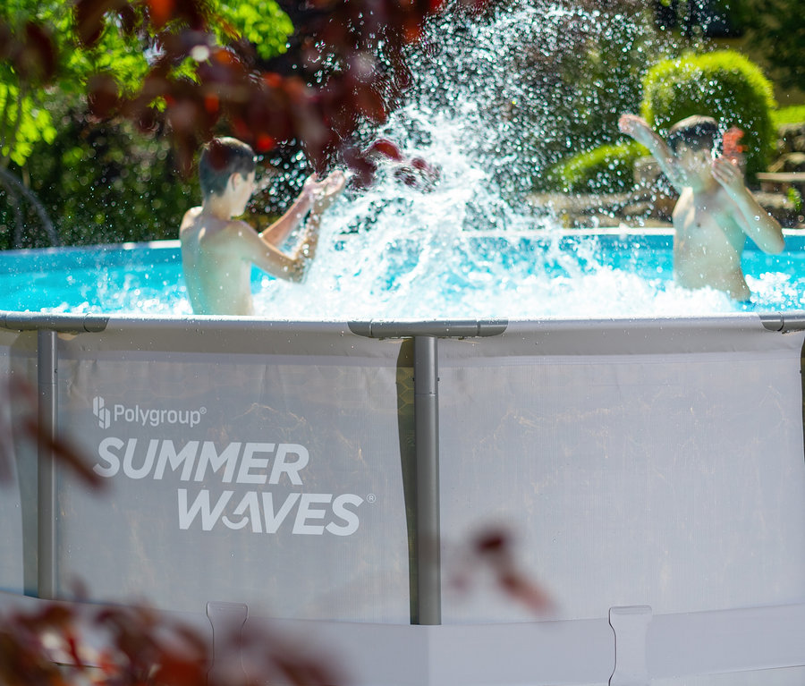 Zwei Jungen spielen im Summer Waves Elite-Frame-Pool, Ø ca. 488 cm, und spritzen mit Wasser.
