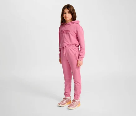 Mädchen trägt rosa HUMMEL HMLJR Base Regular Pants und Hoodie.
