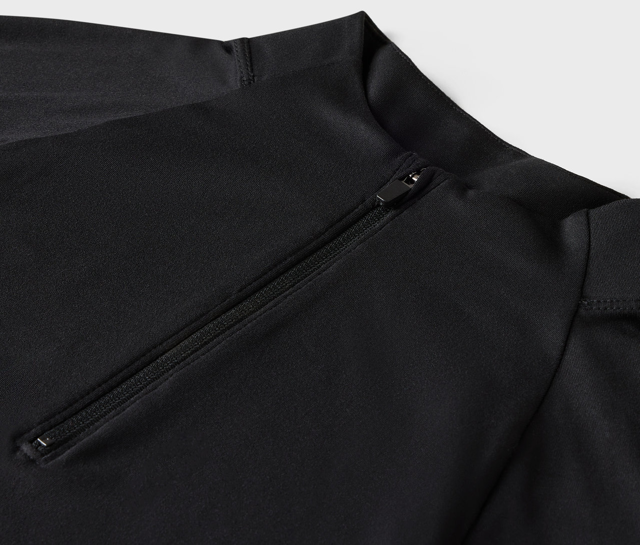 Detailaufnahme eines schwarzen langärmeligen Badeanzugs mit Reißverschluss.