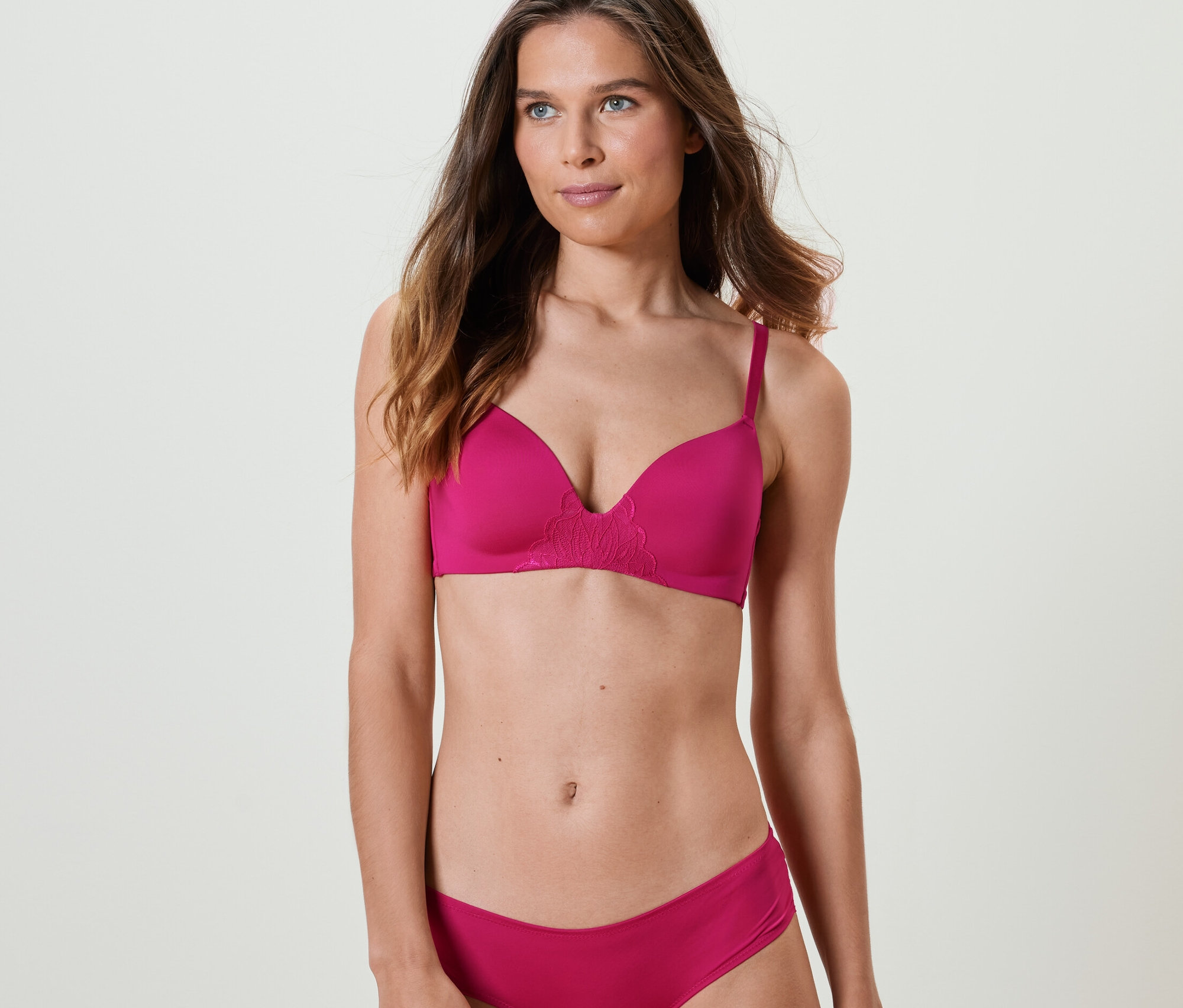 Frau trägt einen fuchsiafarbenen Softschalen-BH und Unterhose.