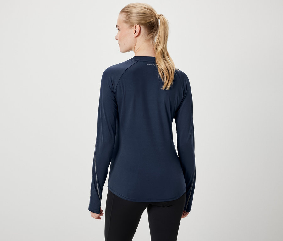 Rückansicht einer Frau mit blonden Haaren, die zu einem Pferdeschwanz zusammengebunden sind, in einem dunkelblauen Langarmshirt und schwarzen Leggings.