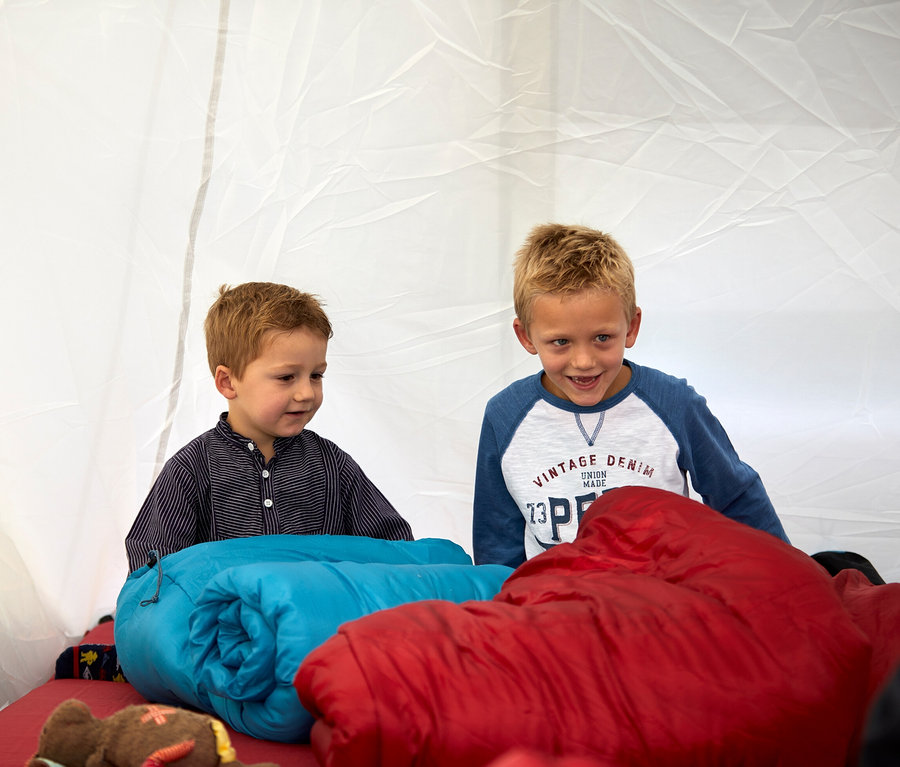 Zwei Jungen im Zelt mit blauer und roter Grand Canyon Doppel Isomatte »Hancock 7.5« und einem Teddybär.