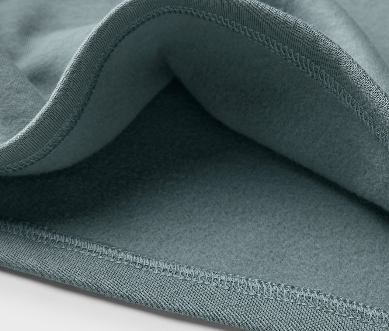 Detailansicht eines blauen Kinder-Sweatshirts mit angerauter Innenseite.