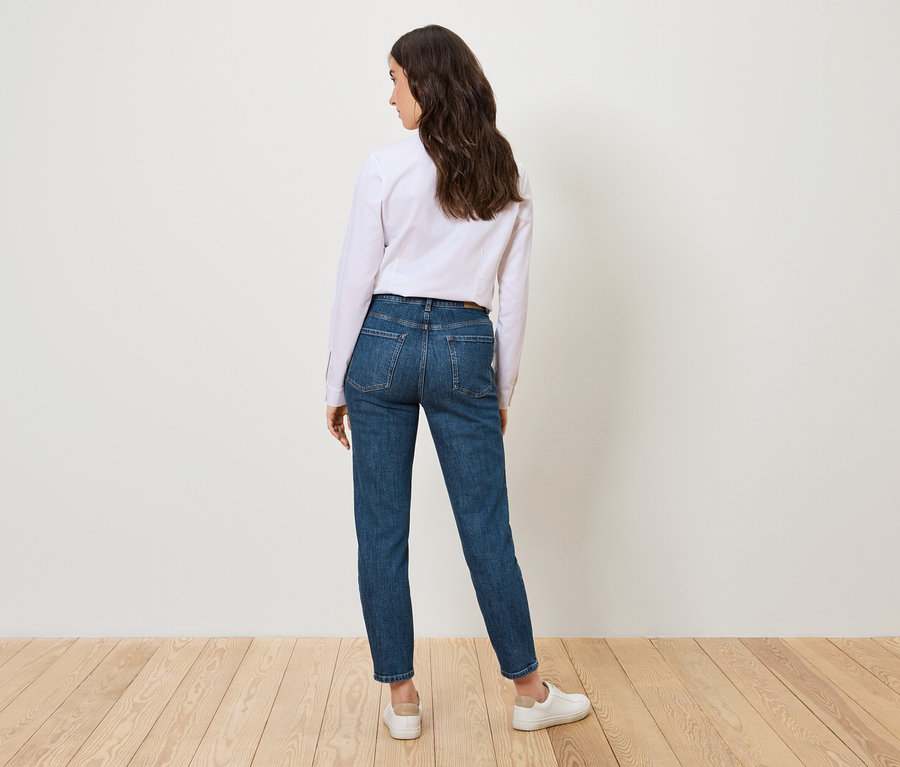 Frau steht mit dem Rücken zur Kamera und trägt eine Mom Jeans – Fit »Nyla«, mid blue.