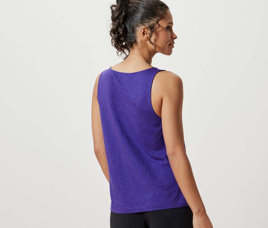 Eine Frau von hinten trägt ein lila Top aus Modalmix und eine schwarze Hose.