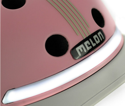 Detailansicht eines rosafarbenen Melon E-Series Fahrradhelms »Lotus« mit Belüftungslöchern und grauem Schirm.