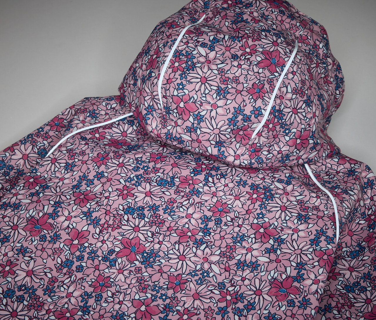 Detailansicht einer Kinder-Thermo-Regenjacke mit Blumenmuster.