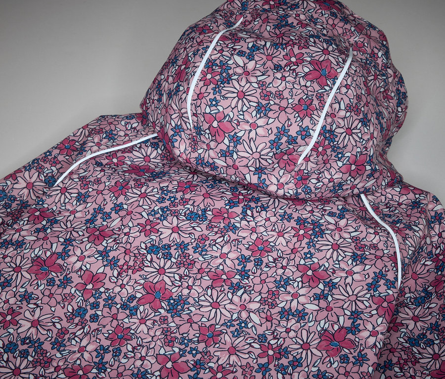 Detailansicht einer Kinder-Thermo-Regenjacke mit Blumenmuster.