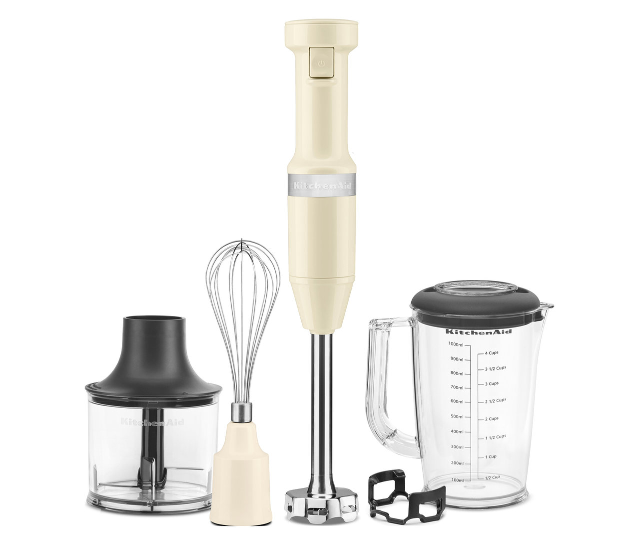 Ein cremefarbener KitchenAid Stabmixer mit Zubehöraufsätzen steht auf einer weißen Oberfläche.