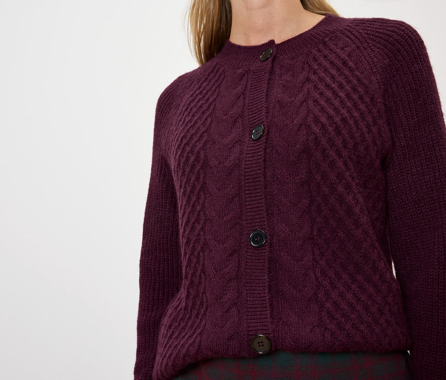 Frau trägt eine violette Strickjacke.