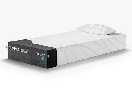 Eine TEMPUR Form™ Plus Matratze, medium, mit einem weißen, gemusterten Kissen darauf.