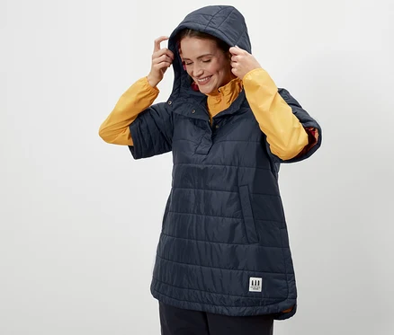 Frau setzt die Kapuze eines Outdoor-Ponchos auf.