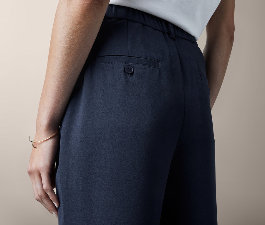 Frau trägt eine Hose mit Bundfalte.