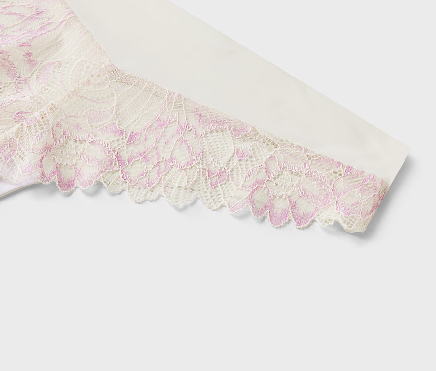 Detailansicht eines weißen Stoffes mit rosa Blumenmuster-Spitze an einem Ärmel.