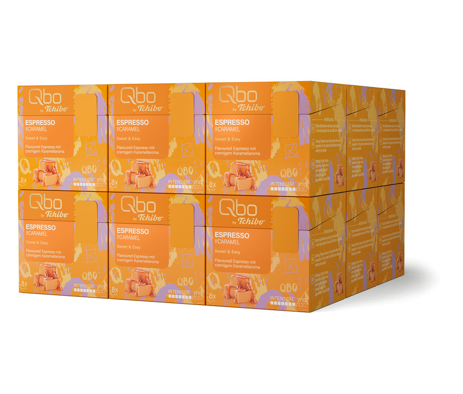 Sechs orangefarbene Qbo by Tchibo Espresso Caramel-Packungen sind in zwei Stapeln angeordnet.