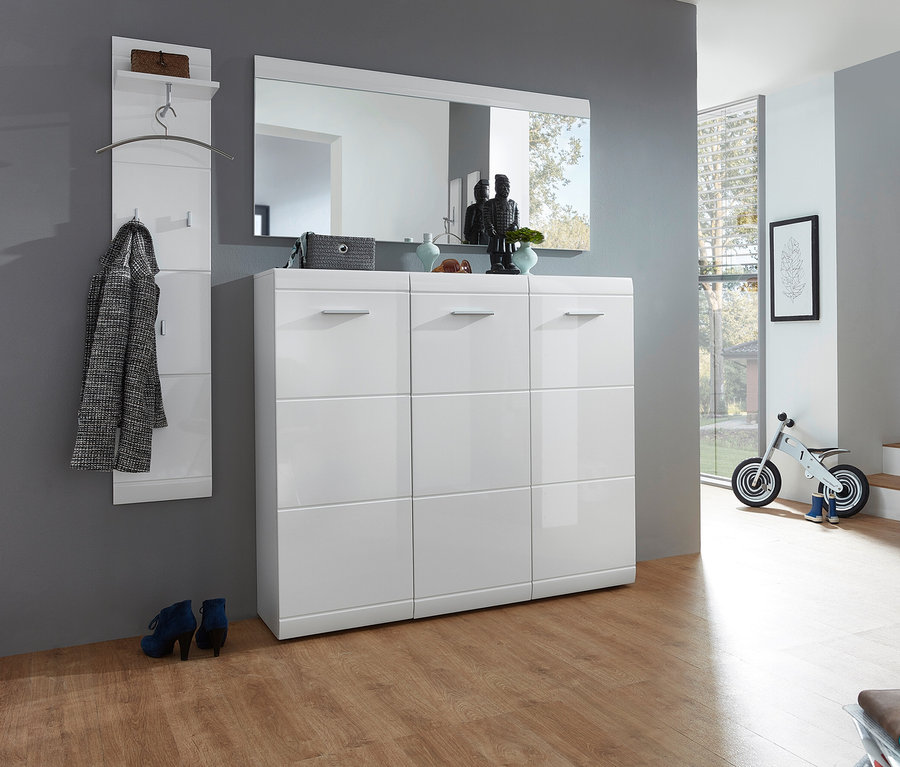 Flur mit weißem Schuhschrank »ADANA« mit drei Türen, Spiegel und Garderobe an grauer Wand. Blaue Schuhe stehen davor.