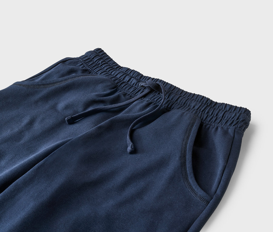Nahaufnahme einer marineblauen Jogginghose mit Kordelzug und Taschen.