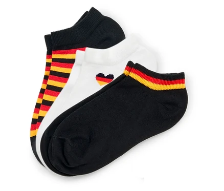 Drei Paar Socken liegen übereinander: schwarz, weiss mit Herz in den deutschen Farben und schwarz-rot-gold gestreift.