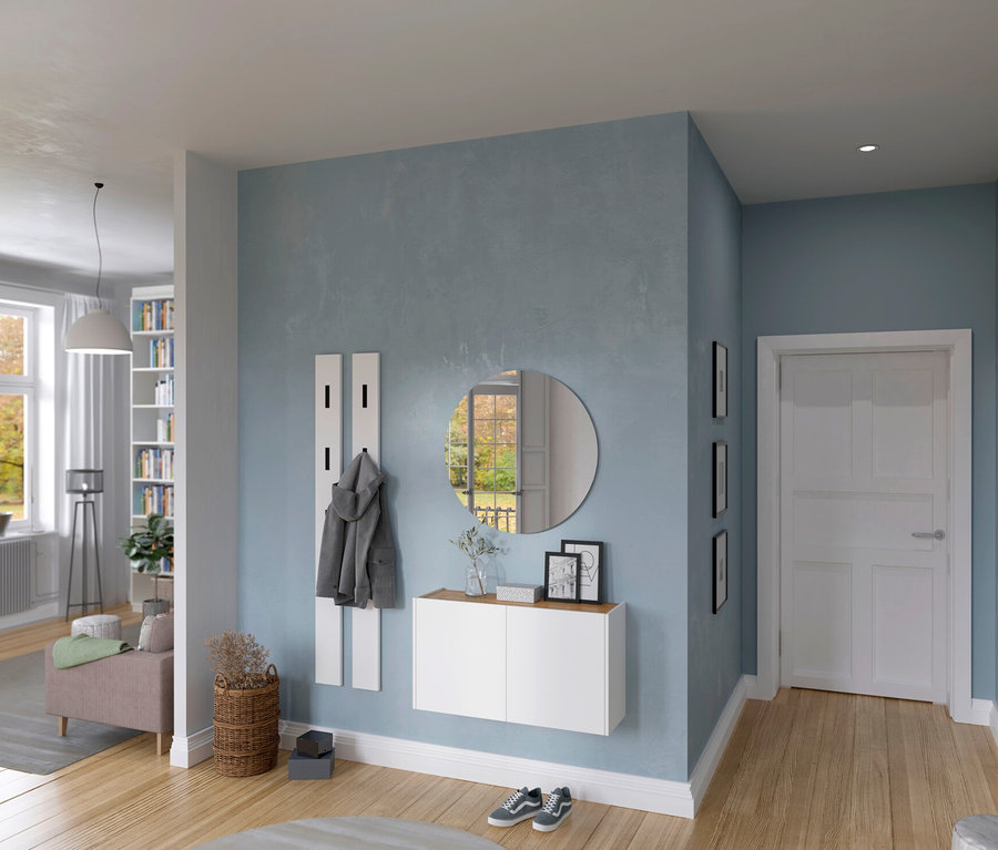 Flur mit hellblauen Wänden, Garderobe mit Spiegel, weißem Schrank und Hakenleiste. Im Hintergrund Wohnzimmer mit Fenster und Bücherregal.
