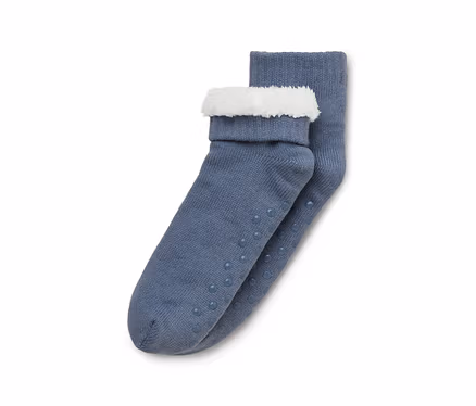 Ein Paar blaugraue Strickstrümpfe mit weißen flauschigen Bündchen und Anti-Rutsch-Noppen an den Sohlen.