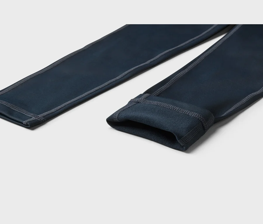 Dunkelblaue Leggings mit grauen Nähten und weichem, flauschigem Innenfutter, auf hellem Hintergrund liegend.