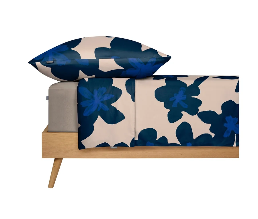 SCHIESSER Renforcé-Bettwäsche »Blossom« mit dunkelblauen Blumen auf beigem Hintergrund auf einem Holzbett.