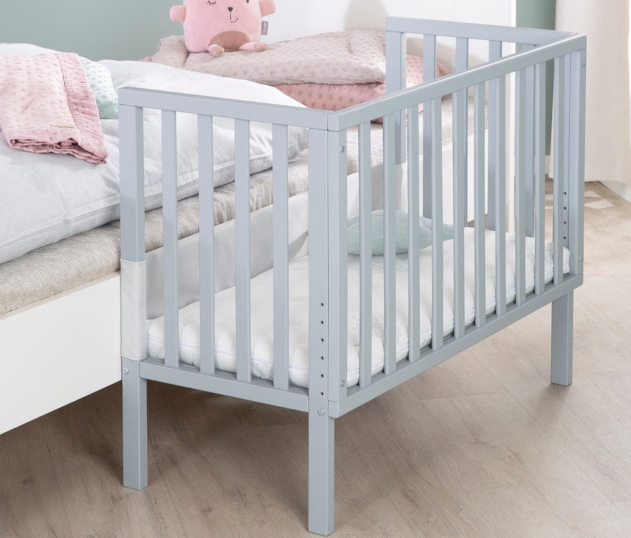 Graues roba 2-in-1-Beistellbett »safe asleep®«, taupe, steht neben einem großen Bett.