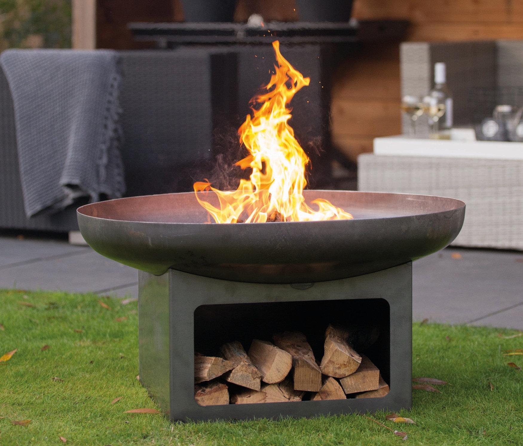 Feuerschale »Juva Industrial«, ca. 80 cm, mit Feuer und Holz auf Rasen.