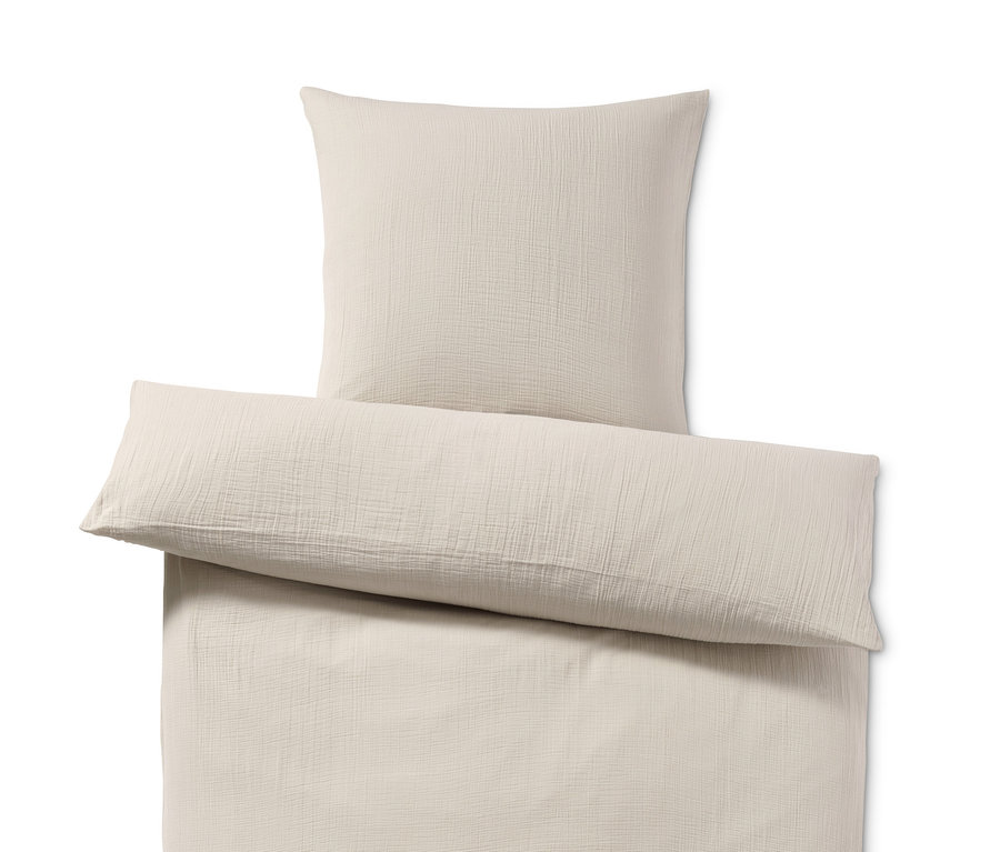 Ein beiges Vestio-Musselin-Bettwäsche-Set in Normal- und Übergröße, bestehend aus einem Bettbezug und einem Kissenbezug.