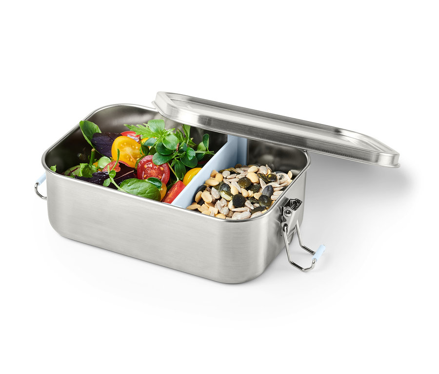 Geöffnete To-go-Lunchbox mit Tomaten, Salat und Samen.