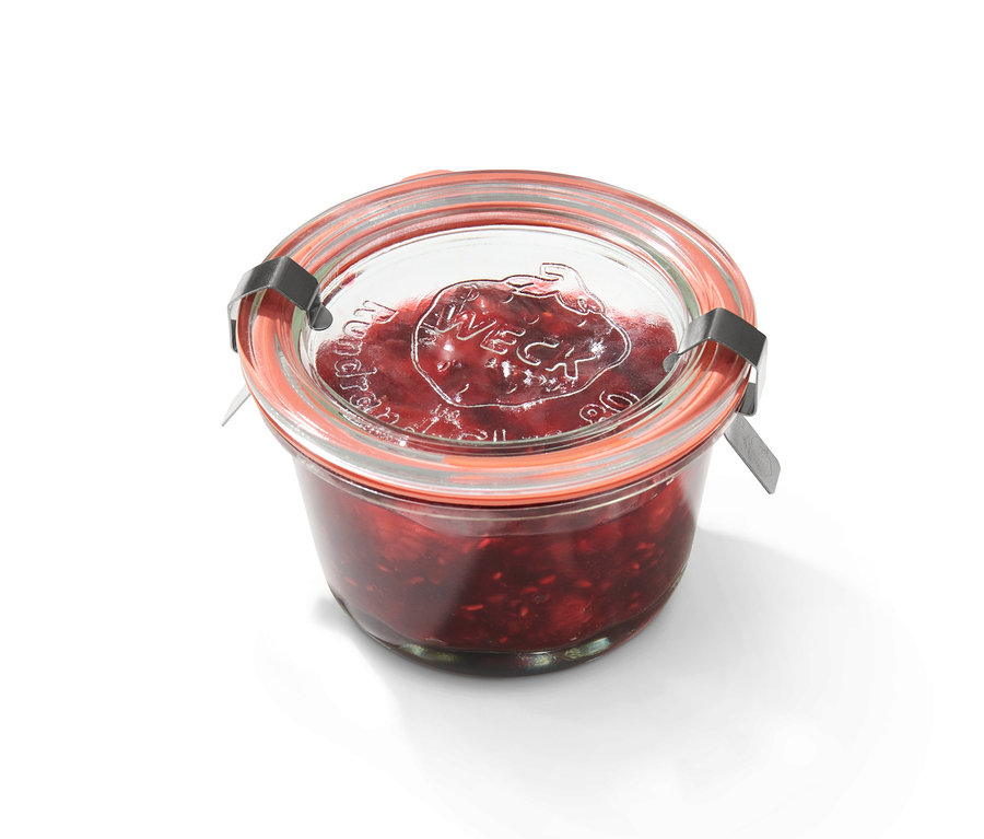 Einmachglas mit roter Marmelade. Auf dem Glas steht 'Weck'.